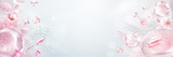 A decorative cosmetic-themed background with pink liquid droplets, clear glass spheres, soft floral elements, and a large empty central area on a pale gray-white backdrop.