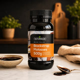 Naturmade Blackstrap Molasses bottle on a marble kitchen counter alongside a bowl and spoon with molasses
