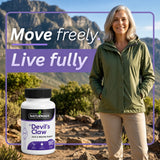 Senior woman standing outdoors on a hiking trail next to a Naturmade Devil's Claw bottle.
