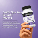 Hand holding Naturmade Devil's Claw bottle showcasing 400mg root extract standardised to 5% harpagosides.
