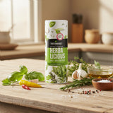 Herbalicious herb salt container on a kitchen table with fresh basil, rosemary, garlic, and chili peppers